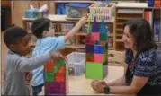  ?? ERIC BONZAR — THE MORNING JOURNAL ?? Maria Moriarti, assistant educator with Elyria City School District’s Early Childhood Village, watches over 4-yearolds Ca’martez Shields, foreground, and Malachi Foy as they build castles with translucen­t building pieces, Sept. 28. The district has...