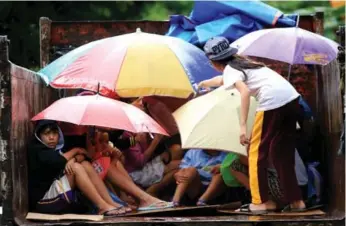  ?? AFP/GETTY IMAGES ?? Young Filipinos wait to be evacuated from the Albay province as the typhoon Nock-Ten approaches in 2016.