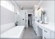  ??  ?? Accentuati­ng the master bath are a roomy double-sink vanity, a sparkling jetted tub and a walk-in shower.