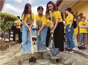  ?? (Foto Mohd Amirul Faiz Ahmad/bh) ?? Tiga pelajar dari Kolej Yuanpei Universiti Shaoxing China, membancuh simen ferro mendirikan papan tanda di SK Kampung Senari, semalam.