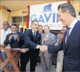  ?? Al Seib Los Angeles Times ?? ERIC GARCETTI, center, endorses Gavin Newsom for governor. The 17-year City Hall veteran is far down the list of potential Democratic presidenti­al nominees.