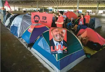  ?? SERGIO LIMA/GETTY-AFP ?? Returning leader in Brazil: Supporters of President-elect Luiz Inacio Lula da Silva camp Saturday at an exhibition hall in Brasilia, Brazil. Lula, 77, defeated far-right President Jair Bolsonaro in October, but many of Bolsonaro’s most die-hard supporters believed the election results to be fraudulent. Lula had been the president of Brazil from 2003 through 2010.