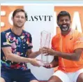  ?? (AFP) ?? Matthew Ebden of Australia and Rohan Bopanna of India hold the trophy after winning the doubles final in Miami yesterday.