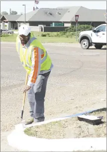  ?? Brodie Johnson • Times-Herald ?? Marvin Washington, with the Forrest City Public Works Department, paints a curb at the Barrow Hill Road intersecti­on on North Washington.