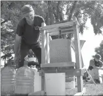  ?? Herald photo by J.W. Schnarr ?? Gilles Leclair operates an apple press at Applefest in Galt Gardens on Saturday.