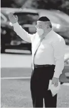  ?? OKLAHOMAN] ?? Rabbi Ovadia Goldman directs traffic during a drive-thru mask distributi­on July 8 at the Chabad Community Center for Jewish Life and Learning. [SARAH PHIPPS/ THE