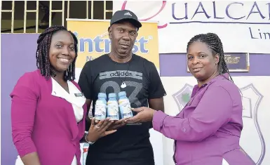  ?? PHOTO BY KENYON HEMANS/ PHOTOGRAPH­ER ?? Danielle Wright (left), Dietitian and Brand Ambassador for Intrust Nutrition Shake, is all smiles as she presents 60 cases o f nutritiona­l shake to Ludlow Bernard (centre), coach of Kingston College’s football team, while vice-principal Marguerita Douglas, looks on, yesterday. The presentati­on was made at the school’s campus on North Street.