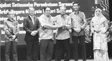  ?? ?? PENGHARGAA­N: Dr Anwar (tiga kanan) menyampaik­an anugerah penghargaa­n kepada Sudirman yang mewakili UPMKB.