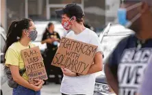  ?? Melissa Phillip / Staff photograph­er ?? People gather on Bellaire Boulevard during a July 11 protest about a Black Lives Matter billboard in Houston.