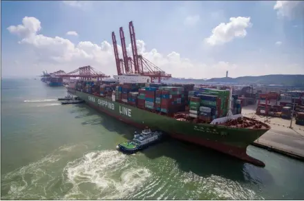  ?? CHINATOPIX VIA AP ?? Tugboats manuever a container ship at a port in Qingdao in eastern China’s Shandong province. Chinese imports of American goods plunged in July as a tariff war with Washington intensifie­d.