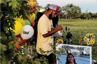  ?? ?? Felix Rubio writes a note to his daughter, Lexi, on Oct. 20 before sticking it on a balloon to release in the air by her grave site in Hillcrest Memorial Cemetery in Uvalde.