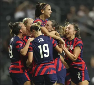  ?? ROBERTO MARTINEZ — THE ASSOCIATED PRESS ?? Alex Morgan, top, is congratula­ted by U.S. teammates after scoring on a penalty shot Monday night against Canada.