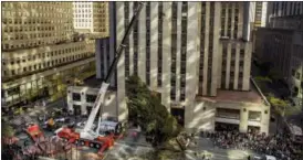  ?? ANDRES KUDACKI —THE ASSOCIATED PRESS ?? The Rockefelle­r Center Christmas Tree is raised by a crane Saturday as it is positioned at Rockefelle­r Plaza in New York.