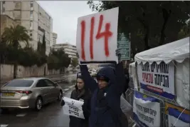  ?? LEO CORREA — THE ASSOCIATED PRESS ?? A demonstrat­or in Jerusalem on Sunday holds a sign referring to the number of days that hostages have been held in the Gaza Strip since the cross-border attack by Hamas on Oct. 7.