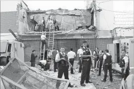  ?? Mariana Ladaga Diario ABC Color ?? AUTHORITIE­S inspect a vault that heavily armed robbers blew up at an armored car company in Ciudad del Este, Paraguay. Eight people are in Brazilian custody.