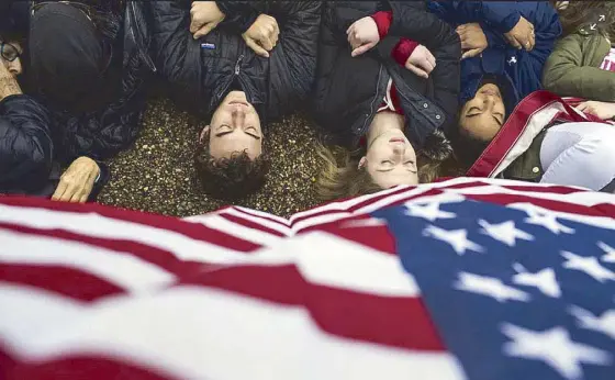  ?? Reuters ?? Activists lie on the ground during a rally for gun control reform near the White House last week. Marjory Stoneman Douglas High School students returned to class on Wednesday, following the Feb. 14 mass shooting that killed several students and teachers.