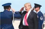  ?? THE ASSOCIATED PRESS ?? President Donald Trump, center, salutes the U.S. Air Force security detail at Orlando Internatio­nal Airport on Friday.