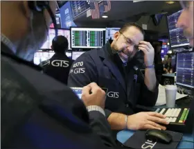  ?? RICHARD DREW — THE ASSOCIATED PRESS ?? Specialist Anthony Matesic, center, works with traders at his post on the floor of the New York Stock Exchange on Tuesday.