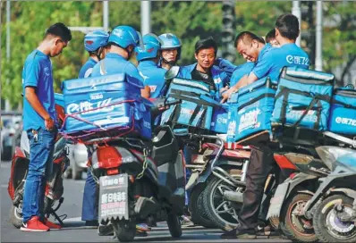  ?? REUTERS ?? Drivers of the food delivery service Ele.me prepare to start their morning shift in Beijing.