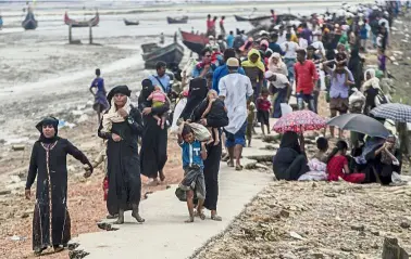  ??  ?? Chased away:
Rohingya after crossing from Myanmar into Bangladesh walking towards the nearest refugee camp in Teknaf, Bangladesh. — AP