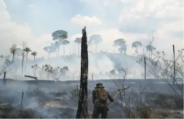  ?? Leo Correa / Associated Press 2019 ?? A Brazilian soldier puts out fires last year in a forest area near the town of Novo Progresso, Brazil.