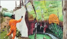  ?? OTIATO OPALI / CHINA DAILY ?? A member of the Komb Green Solutions group paints a wall in the People’s Park, which has provided a safe space for slum children to play.