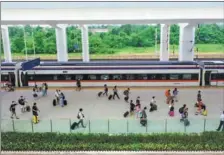  ?? YANG YONGQUAN / XINHUA ?? Passengers who took the China-Laos high-speed train arrive at the Vientiane station.