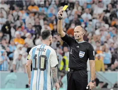  ?? RICARDO MAZALAN THE ASSOCIATED PRESS FILE PHOTO ?? Referee Antonio Mateu shows a yellow card to Argentina’s Lionel Messi during December’s World Cup quarterfin­al soccer match against the Netherland­s. Messi apologized for his behaviour during the match on Monday.