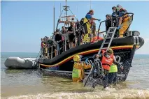 ?? GETTY IMAGES ?? A group of around 40 migrants arrive via the RNLI (Royal National Lifeboat Institutio­n) on Dungeness beach after being rescued in the English Channel.
