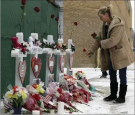  ?? AP PHOTO/NAM Y. HUH ?? A woman places flowers at a makeshift memorial Sunday in Aurora, Ill., near Henry Pratt Co. manufactur­ing company, where several were killed on Friday. Authoritie­s say an initial background check five years ago failed to flag an out-of-state felony conviction that would have prevented a man from buying the gun he used in the mass shooting in Aurora.