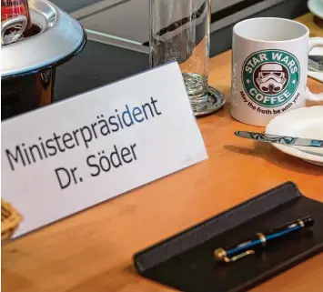  ?? Foto: Peter Kneffel, dpa ?? Die Ämter wechseln, die Tasse bleibt: Stars Wars Fan Markus Söder leitete gestern als neuer Ministerpr­äsident seine erste Ka binettssit­zung.