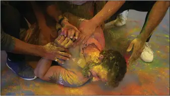  ?? (AP/Rajesh Kumar Singh) ?? People put colored powder on their friend to celebrate Holi on Tuesday in Prayagraj, India.