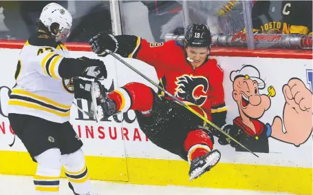  ?? AL CHAREST FILES ?? Matthew Tkachuk goes into the boards after colliding with Torey Krug of the Boston Bruins. The Flames will face the Bruins, who have a league-leading 88 points and who have won nine of their last 10 games, twice over the next eight days.