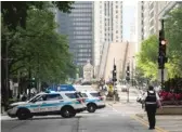  ?? ASHLEE REZIN/SUN-TIMES ?? Police stand guard on the Magnificen­t Mile and the Michigan Avenue Bridge over the Chicago River is lifted after looting broke out overnight in the Loop on Aug. 10, 2020.