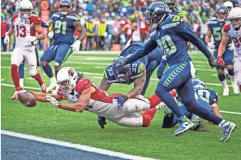  ?? GETTY IMAGES ?? Wide receiver Larry Fitzgerald (11) of the Cardinals stretches out to score a touchdown against the Seahawks Sunday in Seattle.