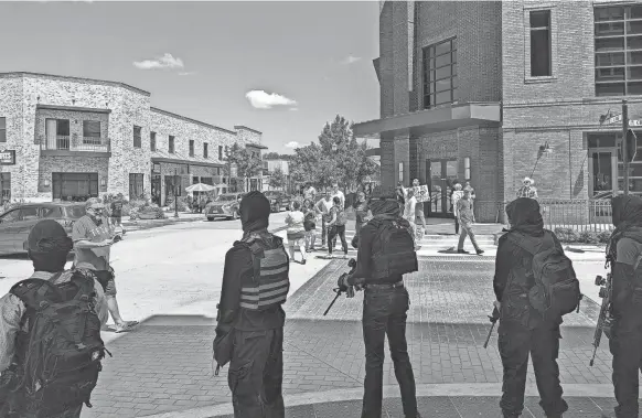  ?? PROVIDED BY STEVEN MONACELLI ?? Members of the Elm Fork John Brown Gun Club stand outside the drag brunch carrying semiautoma­tic rifles. Some also wore Pride flags. When protesters approached the show, members of the gun club directed them to stay back, according to videos from the day.