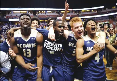  ?? Associated Press ?? UC Davis players celebrate the Aggies’ 50-47 win over UC Irvine in the championsh­ip game of the Big West tournament on Saturday night in Anaheim. The Aggies will play the first NCAA Tournament game in program history tonight against North Carolina...