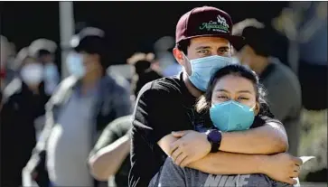 ?? Gary Coronado Los Angeles Times ?? SIBLINGS Ricardo and Kelley Medina waited in line for a free COVID- 19 test Tuesday in Los Angeles. More than 21,400 California­ns have died of the disease, nearly 2,000 of them in the last two weeks.