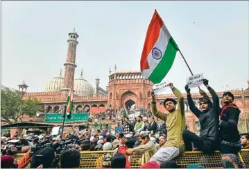 ?? PTI ?? A protester holds the national flag during a protest against Citizenshi­p (Amendment) Act, after Friday prayers, at Jama Masjid on Friday