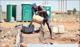  ??  ?? A zama zama pours water through a bucket-turnedsiev­e onto a “Jameson table” in a Johannesbu­rg informal settlement.