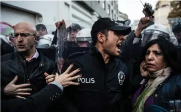  ??  ?? A Turkish riot police officer reacts during clashes with women’s rights activists who tried to march to Taksim Square to protest against gender violence in Istanbul on the Internatio­nal Day for the Eliminatio­n of Violence against Women. — AFP photo