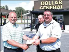  ?? Photo by Mike Eckels ?? Mayor Bob Tharp (left) received a gift of $1,000 from Matt Cooper, Dollar General regional manager, and Scott Frazier (back row), store manager, outside the Dollar General Plus-Plus store on Main Street in Decatur July 21. Dollar General’s donation...