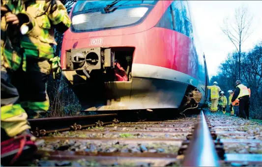  ??  ?? Firemen inspect a regional train that partly derailed after it collided with a tree uprooted by storm “Eleanor” on Wednesday in Selm, Germany.