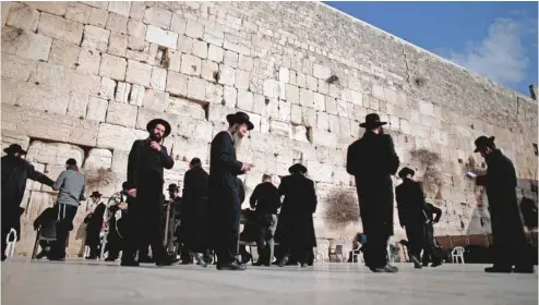  ?? THOMAS COEX AGENCE FRANCE-PRESSE ?? Des hommes issus de la communauté juive ultraortho­doxe prient au mur des Lamentatio­ns. Le lieu de prière est actuelleme­nt ségrégué entre espaces réservés aux hommes et aux femmes.