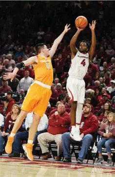  ?? Associated Press ?? Arkansas guard Daryl Macon pulls ups for a jump shot over Tennessee defender John Fulkerson during the first half of an NCAA college basketball game Saturday in Fayettevil­le, Ark.