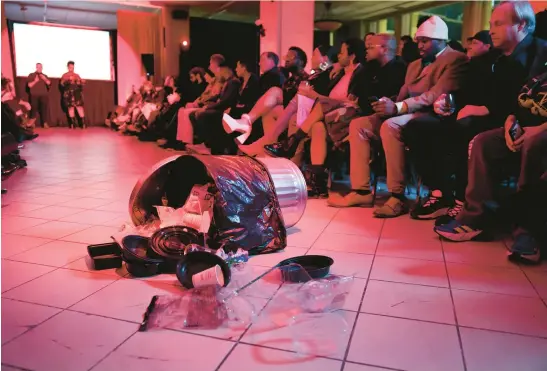  ?? CHRIS SWEDA/CHICAGO TRIBUNE ?? A tipped-over garbage can serves as a statement piece at the end of the runway prior to models featuring designs using single-use plastic products or things that others would consider trash or obsolete at the ShadowBall fashion show at Macy’s on State Street on Jan. 20.