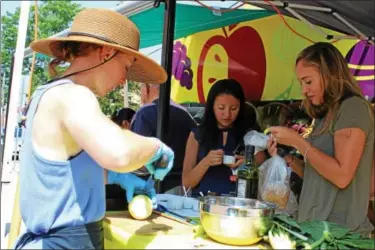  ?? MICHILEA PATTERSON — DIGITAL FIRST MEDIA ?? Samantha Stalford, far left, demonstrat­es how to make a healthy recipe while customers at a fresh produce food truck eat samples in Phoenixvil­le on Wednesday. The Fresh2You Mobile market travels throughout Chester County to sell fresh fruits and...