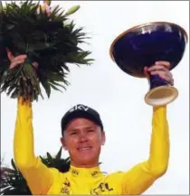  ?? CHRISTOPHE ENA — THE ASSOCIATED PRESS ?? Tour de France winner Chris Froome, wearing the overall leader’s yellow jersey, holds the trophy on the podium after the 21st and last stage of the Tour de France in Paris Sunday.