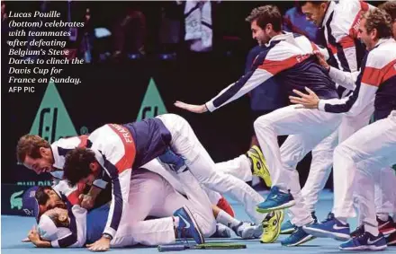  ?? AFP PIC ?? Lucas Pouille (bottom) celebrates with teammates after defeating Belgium’s Steve Darcis to clinch the Davis Cup for France on Sunday.