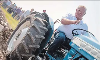  ?? GEOFF ROBINS/THE CANADIAN PRESS ?? Ontario Premier Doug Ford sits on a Ford tractor as he plows a furrow at the Internatio­nal Plowing Match in Pain Court Ont. Tuesday. A letter-writer is critical of Ford’s approach to the downsizing of Toronto city council.